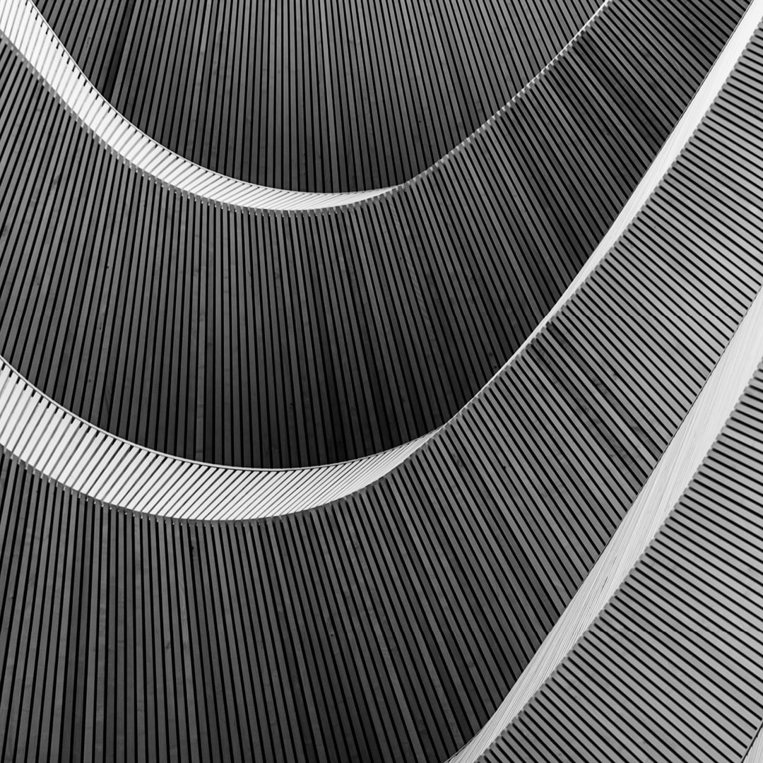 Abstract close-up of curved ribbed architectural surfaces in black and white featured on CBRE's H1 2026 Capital Research Survey report cover.