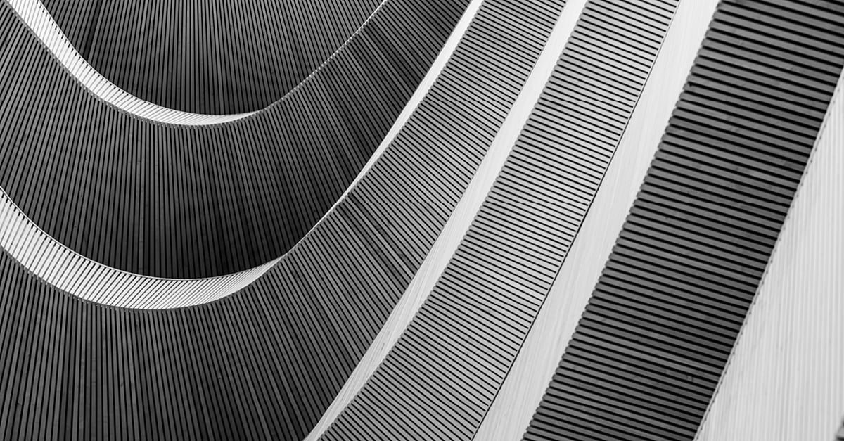 Abstract close-up of curved ribbed architectural surfaces in black and white featured on CBRE's H1 2026 Capital Research Survey report cover.