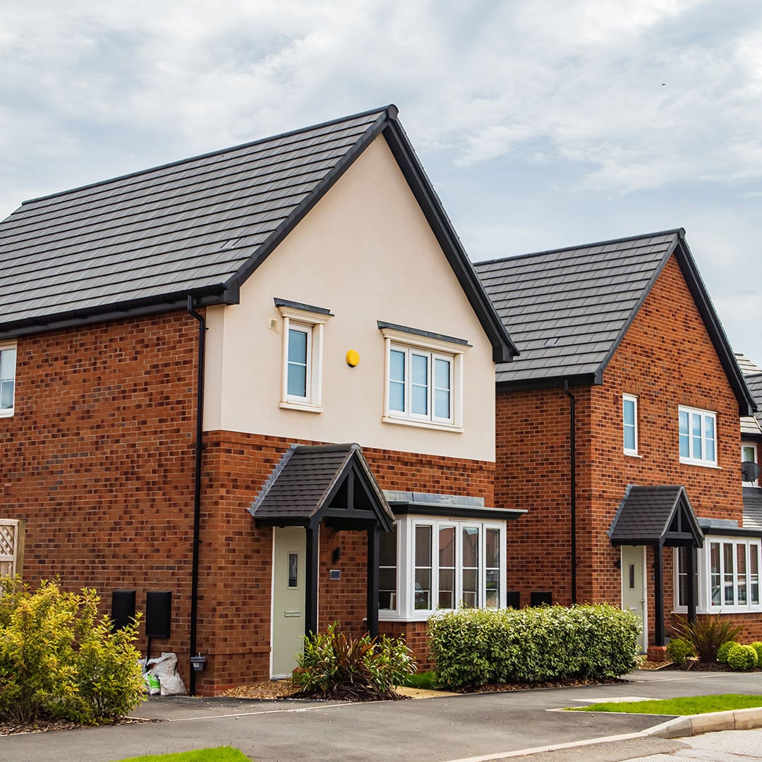 Row of modern red brick semi-detached houses with dark roofs