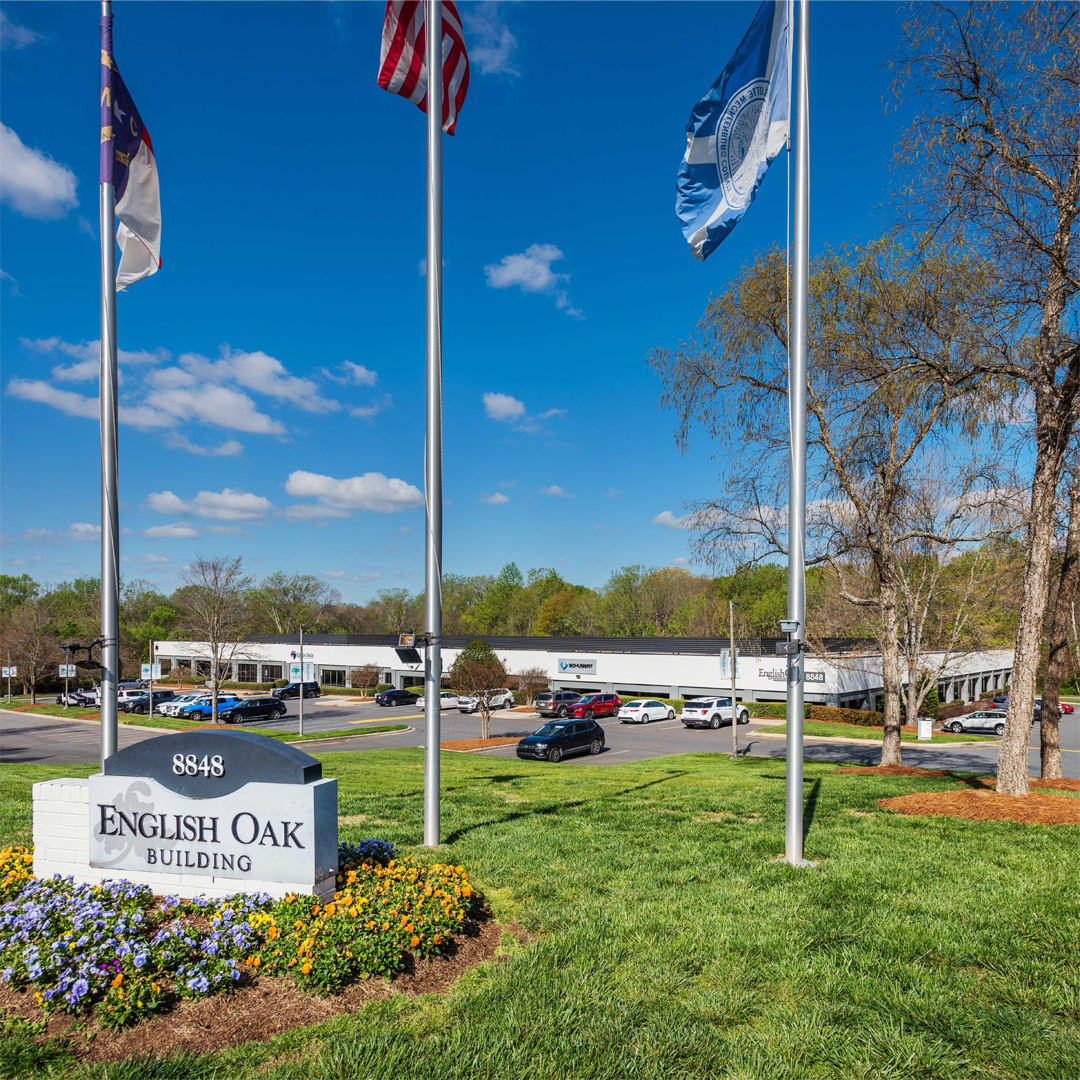 A small office building on a sunny day with green grass