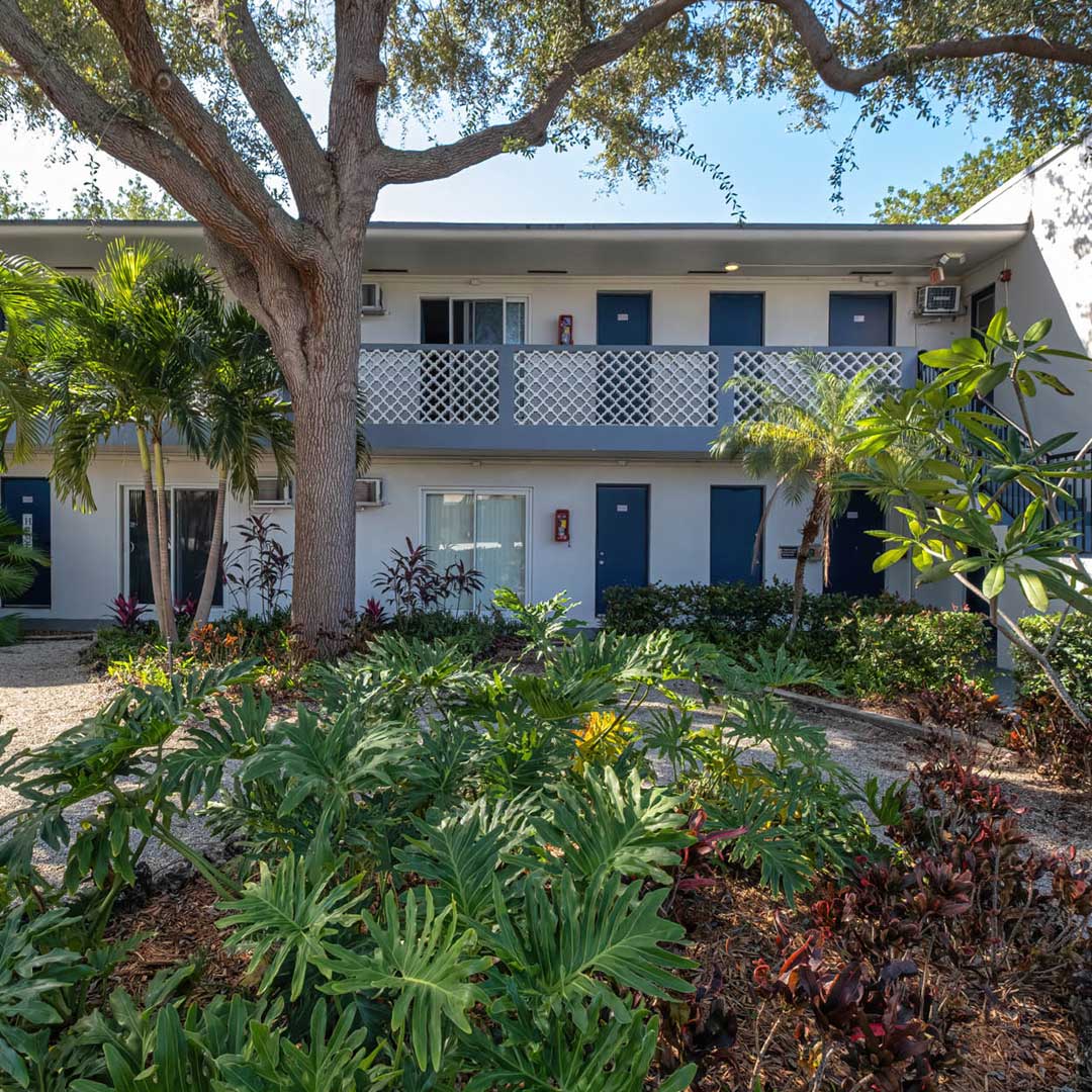 exterior of two story apartment building with trees around it