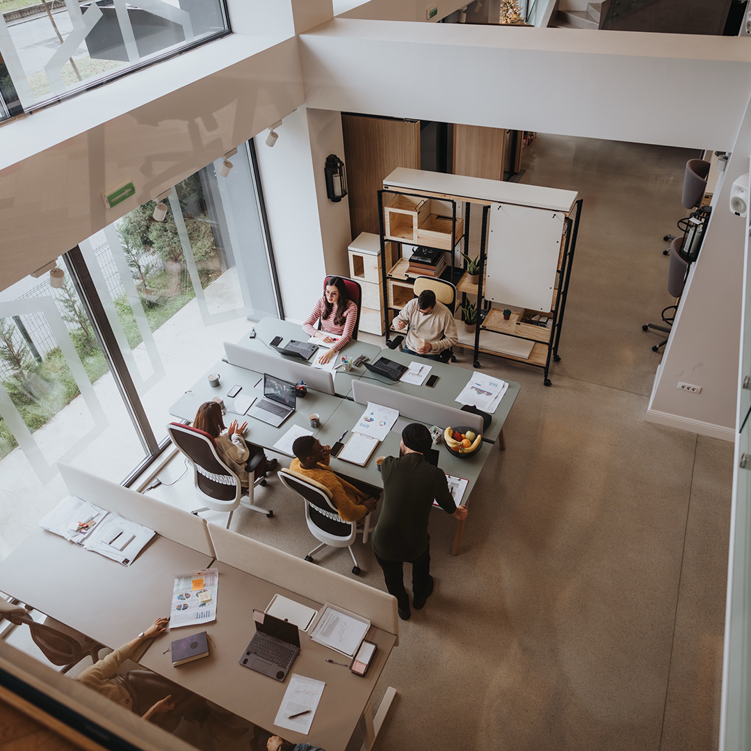 Overhead shot of three people in desks at an office