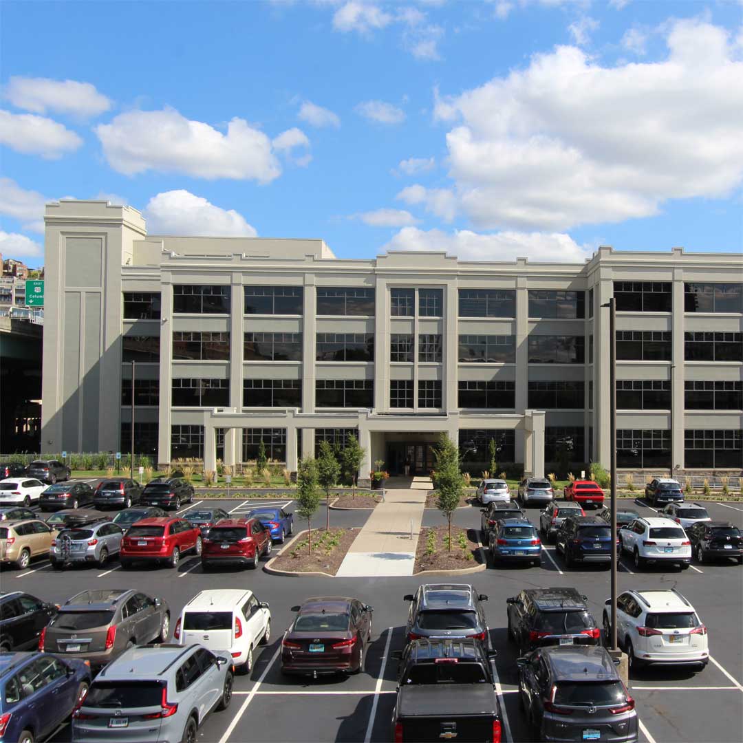 A light tan office building and parking lot