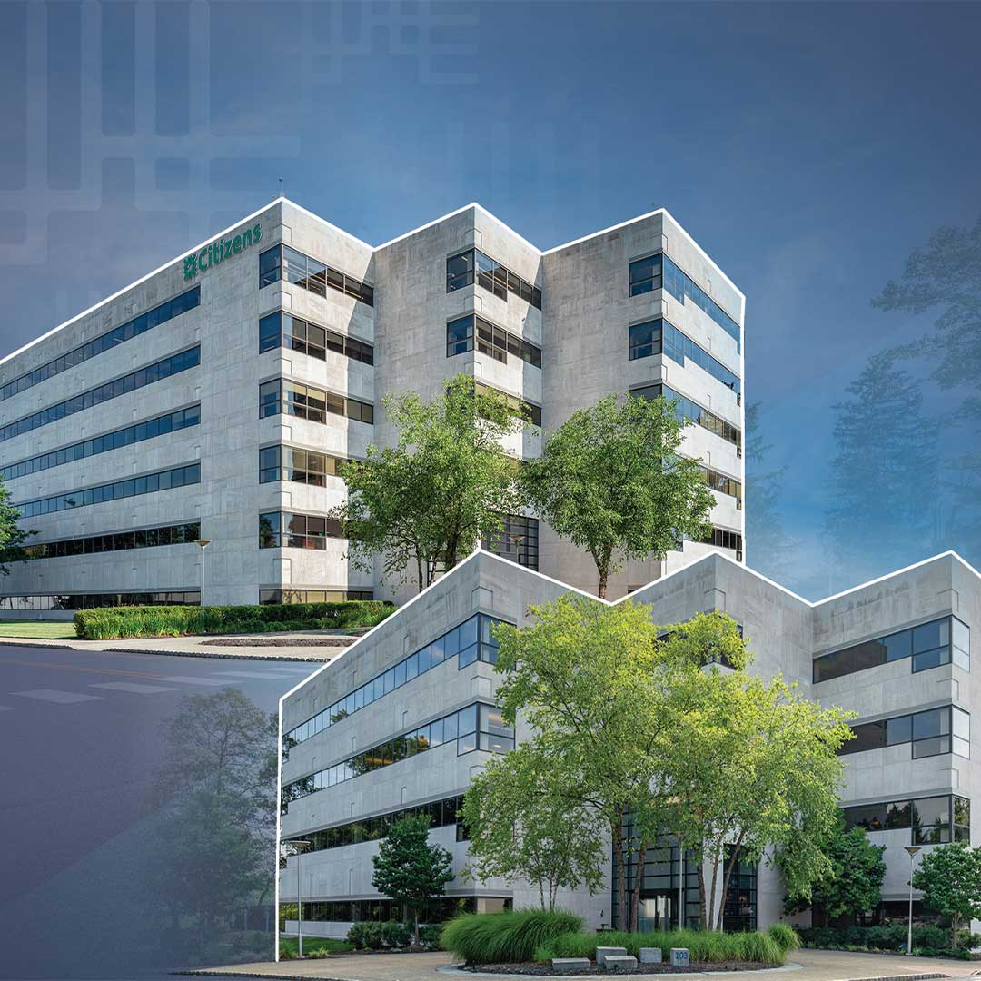 Exterior of two office buildings with trees on the corner of the buildings.