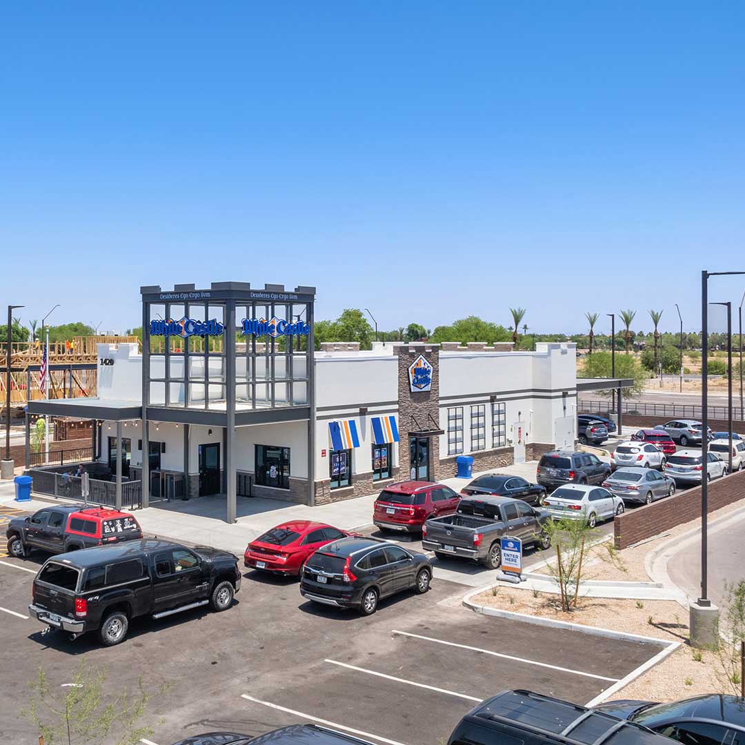 White Castle restaurant with its logo and signage visible, surrounded by a parking lot filled with various cars.