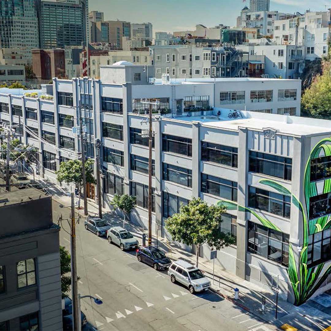 Exterior of 1045 Sansome Street with grey paint and tree lined sidewalk.