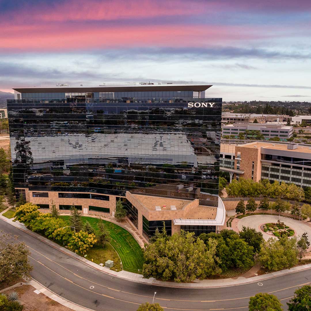 Aerial view of Sony office building with reflective glass facade at sunset.