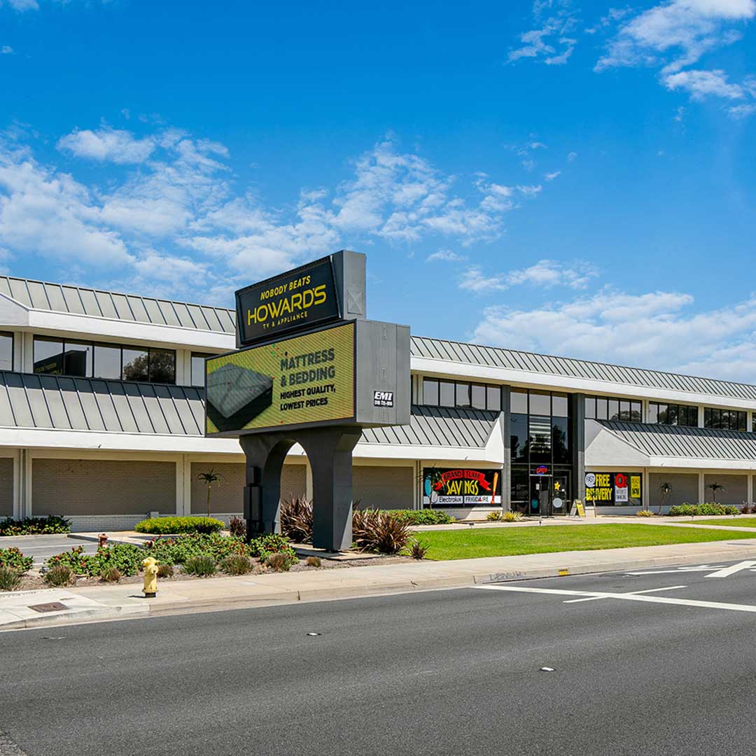 Howard's appliance store with large roadside sign and modern two-story building under blue sky.