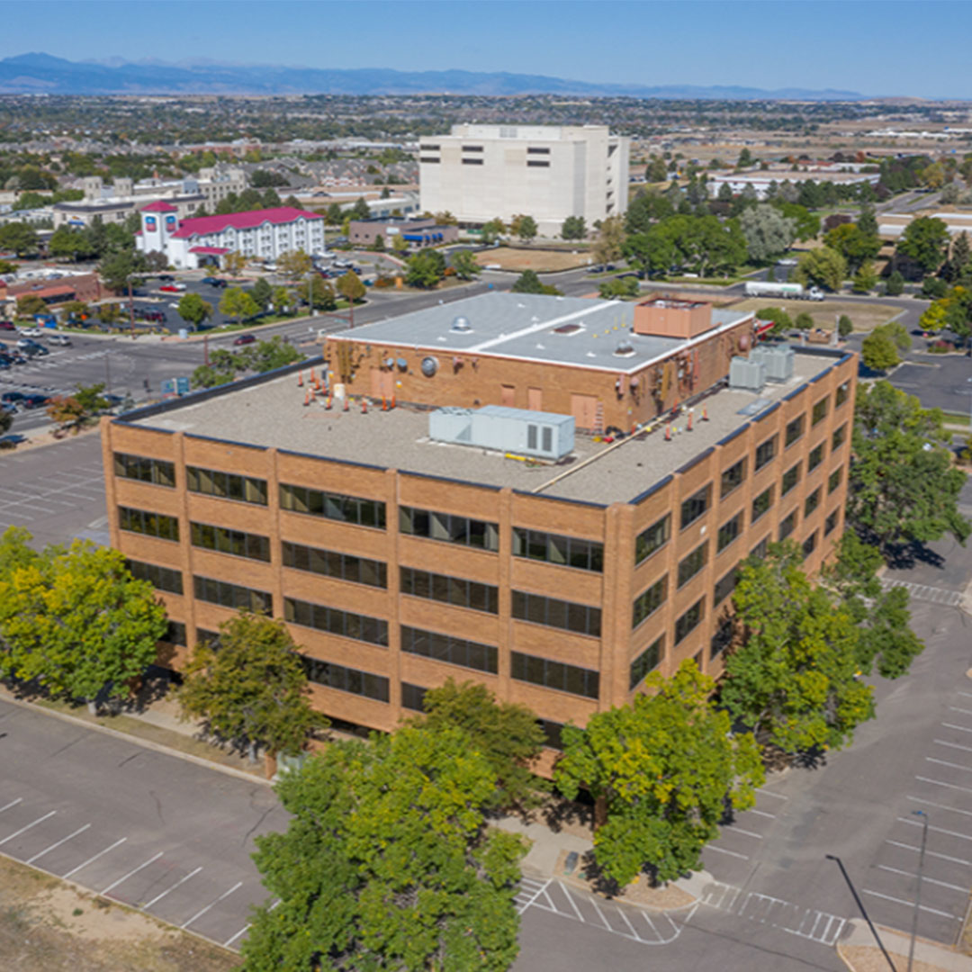 Exterior of Metro North Professional Plaza with brick walls surrounded by trees.