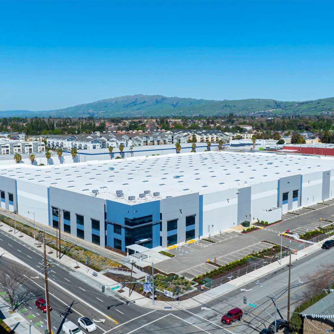 Aerial of blue and white industrial warehouse.