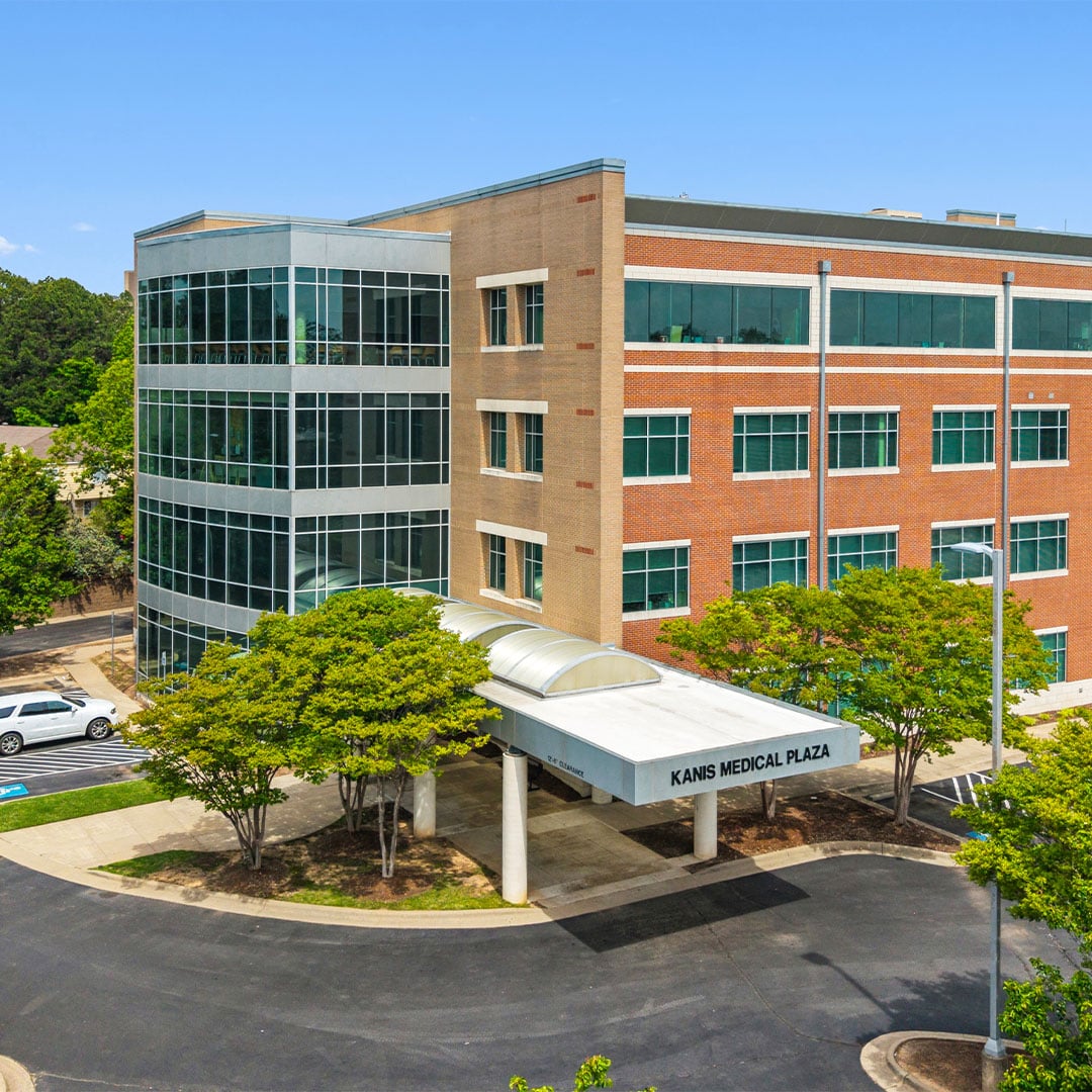 Exterior view of Kanis Medical Plaza, a multi-story medical office building with glass and brick façade, landscaped grounds, and covered entrance.