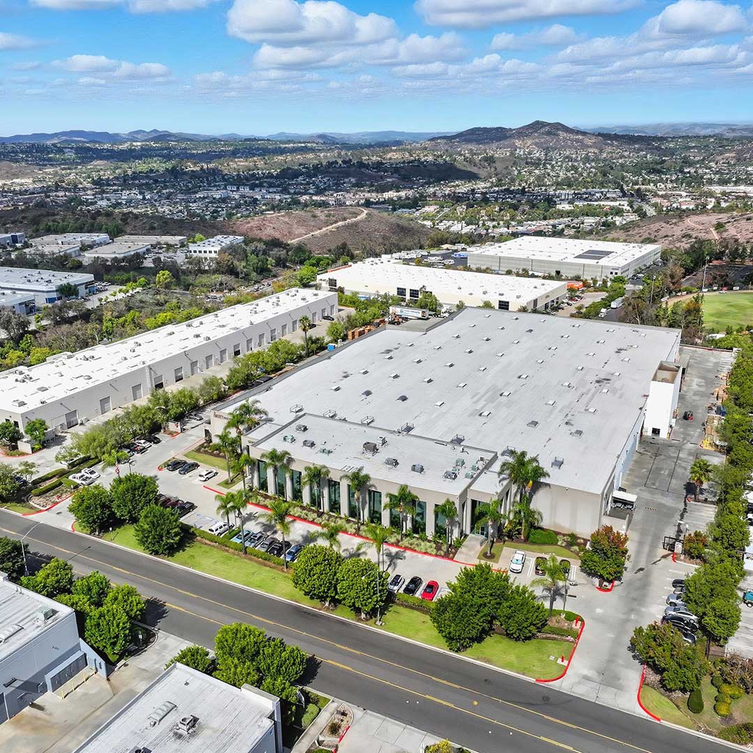 Aerial view of industrial warehouse at 13100 Danielson Street in San Diego, California, surrounded by commercial buildings.