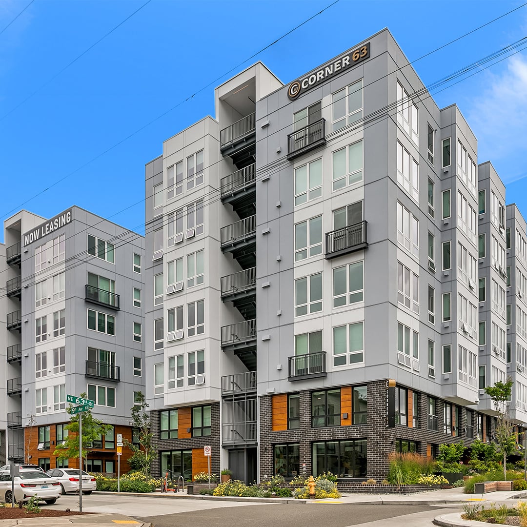Exterior of Corner 63, a modern mid-rise multifamily apartment community at a Seattle street corner