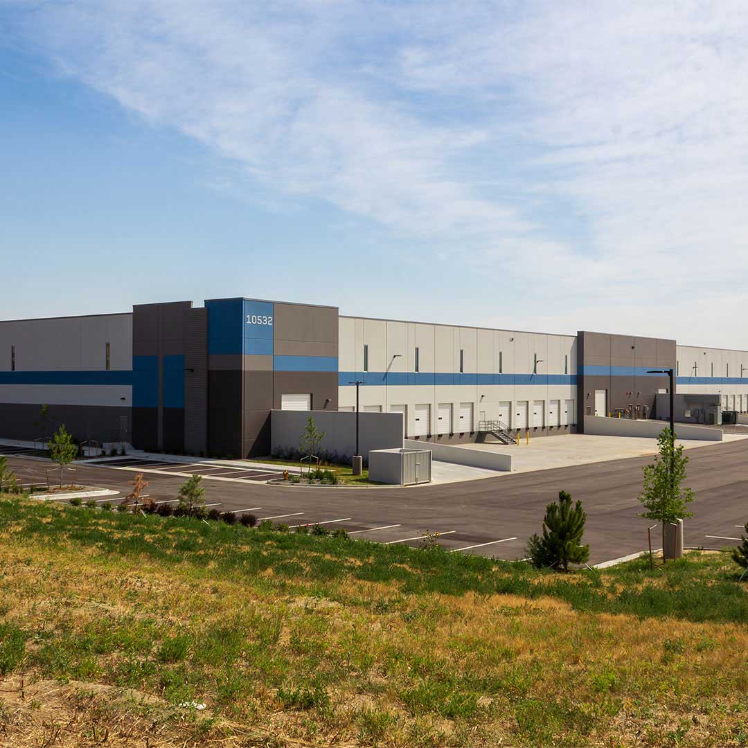 Modern industrial warehouse at Deer Creek Commerce Center with loading docks, distribution space, and ample parking under a clear sky.
