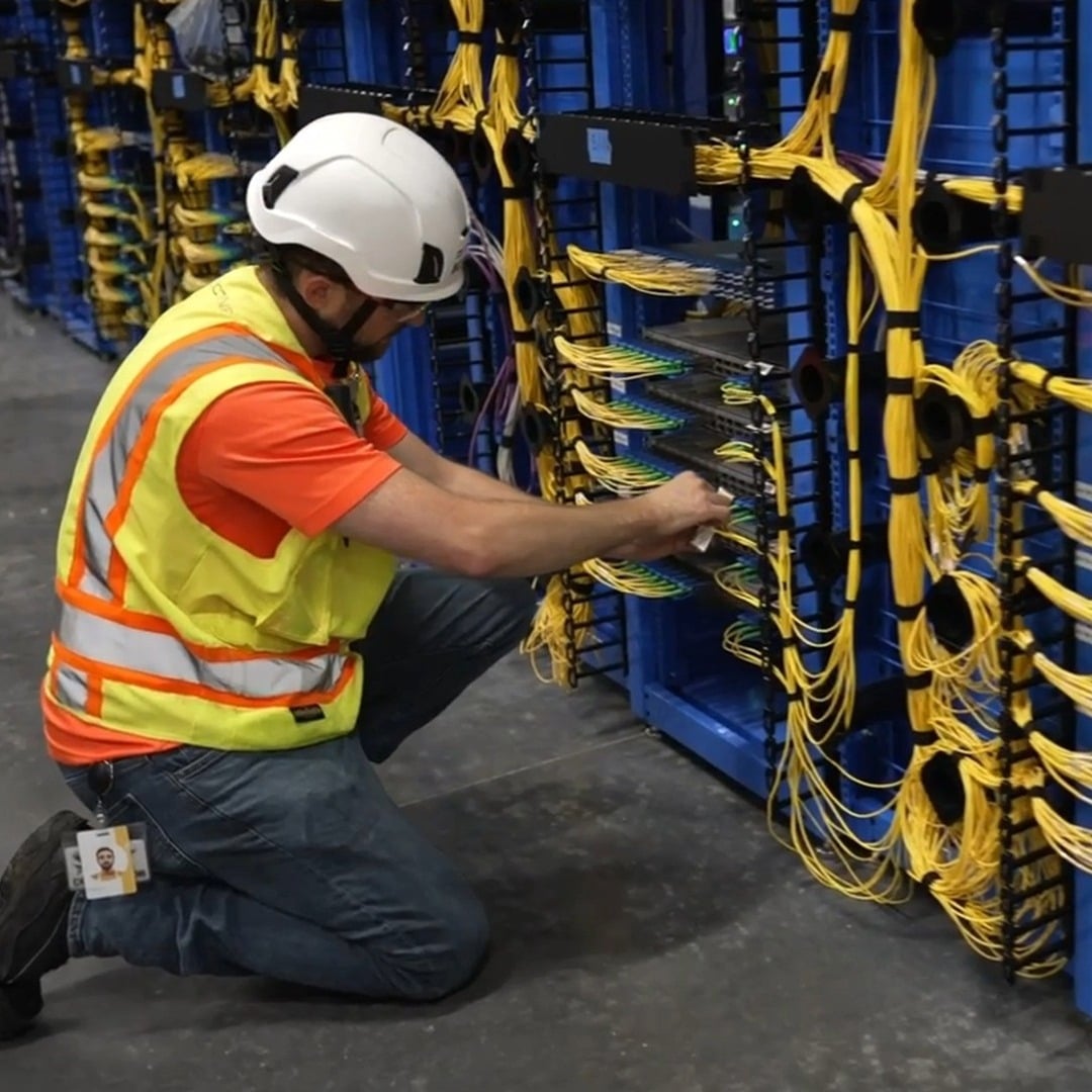 Technician in protective gear working on fiber optic cables