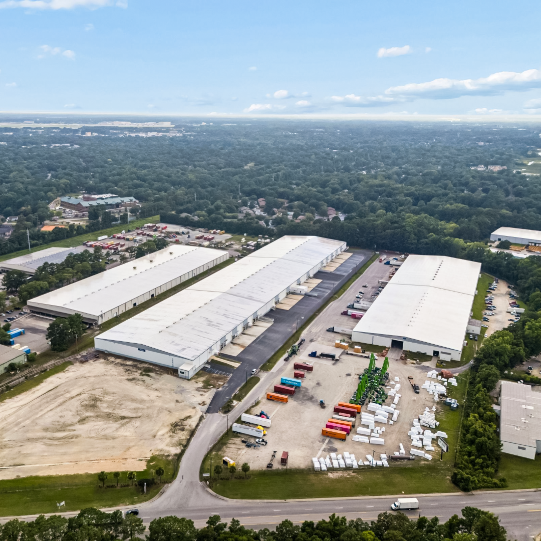 Aerial view of industrial warehouse complex at 5801 N Rhett Ave with loading docks, shipping containers, and truck courts