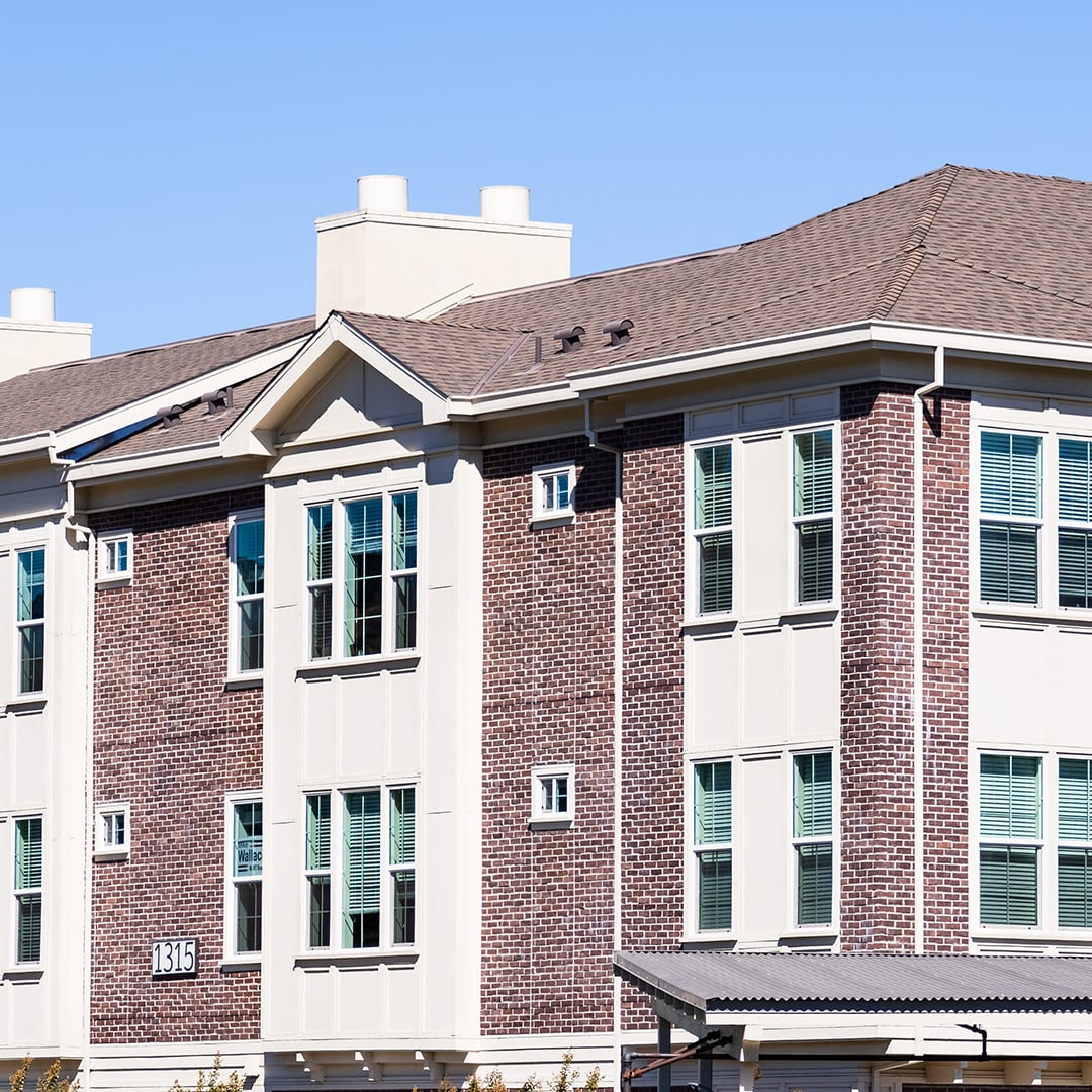 Modern three-story brick multifamily apartment building exterior, United States