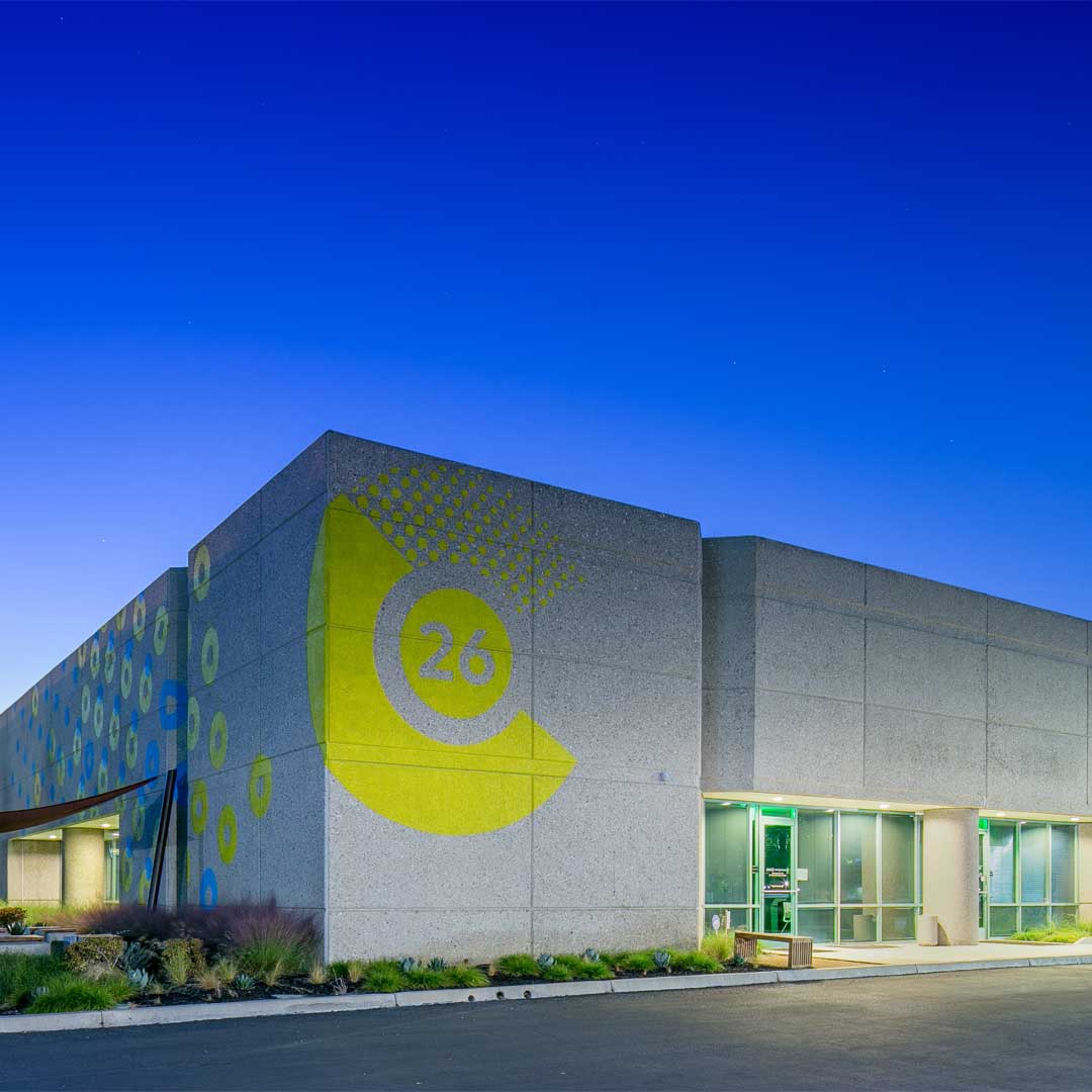 Modern industrial building at Centerpointe26 with exterior lighting and landscaped walkway captured at dusk.