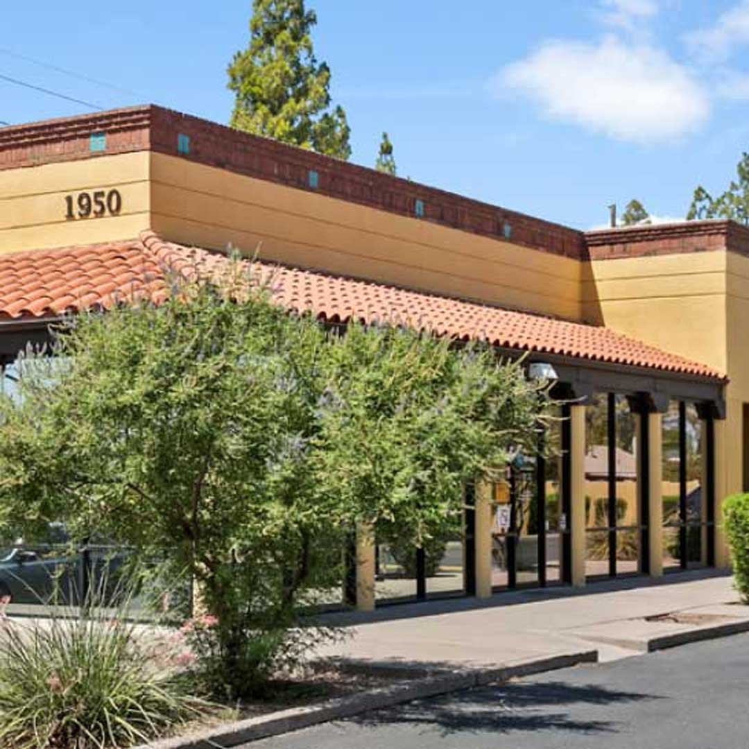 Exterior view of a single-story commercial building in Tempe, Arizona, with a tile roof and large front windows.