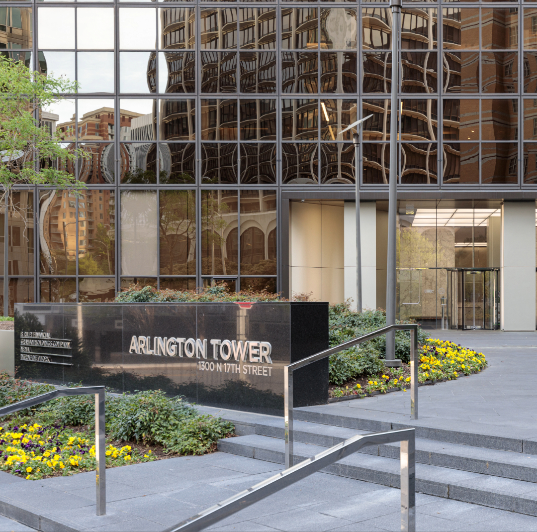Exterior of Arlington Tower at 1300 N 17th Street, a Class A glass office tower in Arlington, VA with granite monument sign and landscaped plaza.