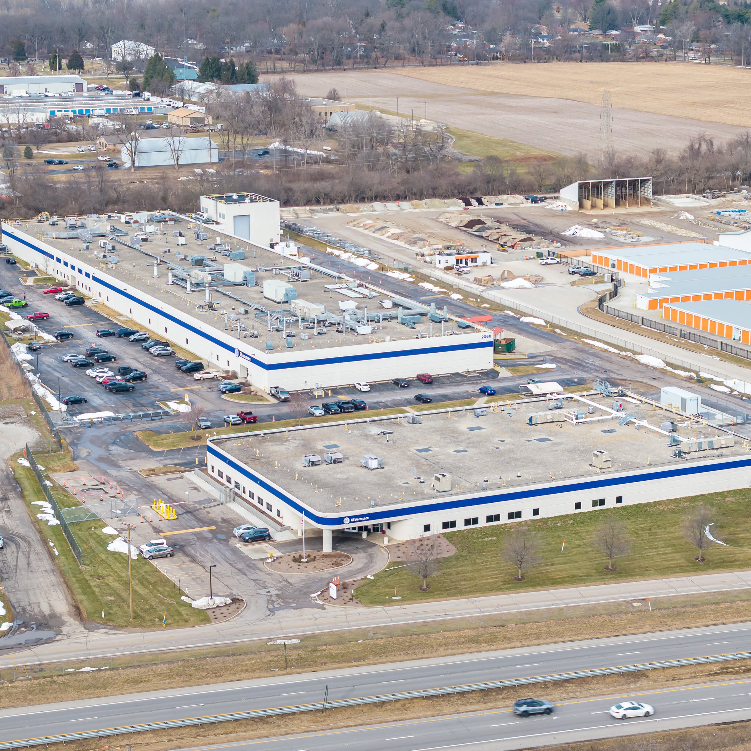 Aerial view of GE Aerospace industrial campus at 2060 and 2070 Heller Drive featuring two large white and blue striped manufacturing buildings with surface parking.