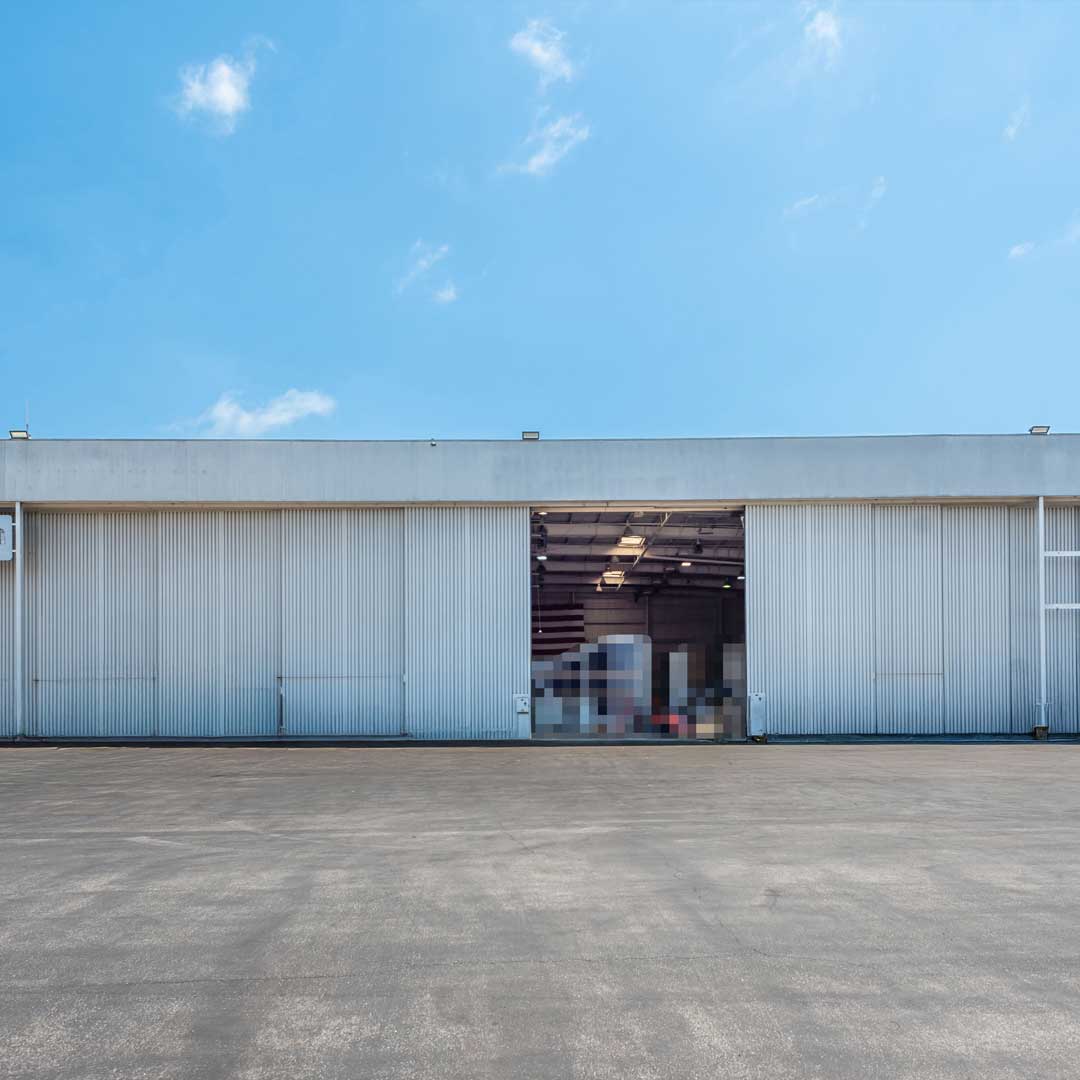 A large open bay door revealing interior space (likely storage, logistics, or aviation-related use)