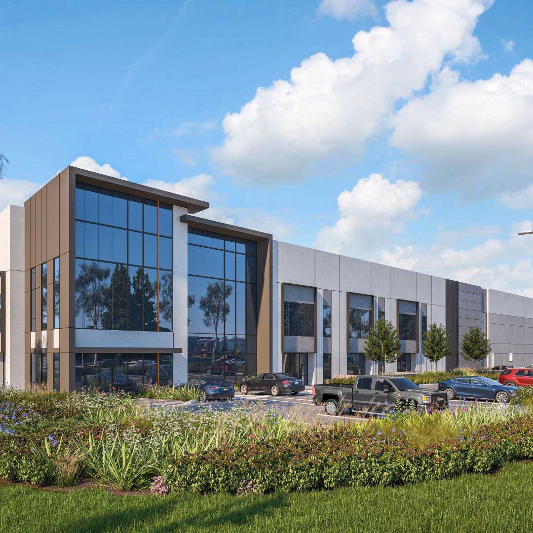 Modern industrial development building with glass façade, landscaped greenery, and parked vehicles under a clear blue sky.