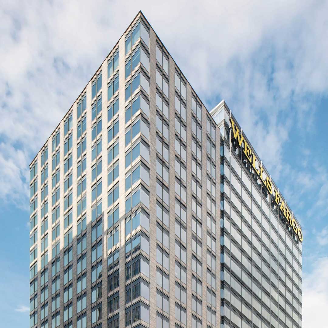Wells Fargo office tower in Midtown Atlanta featuring a modern glass facade and high-rise corporate building against a blue sky