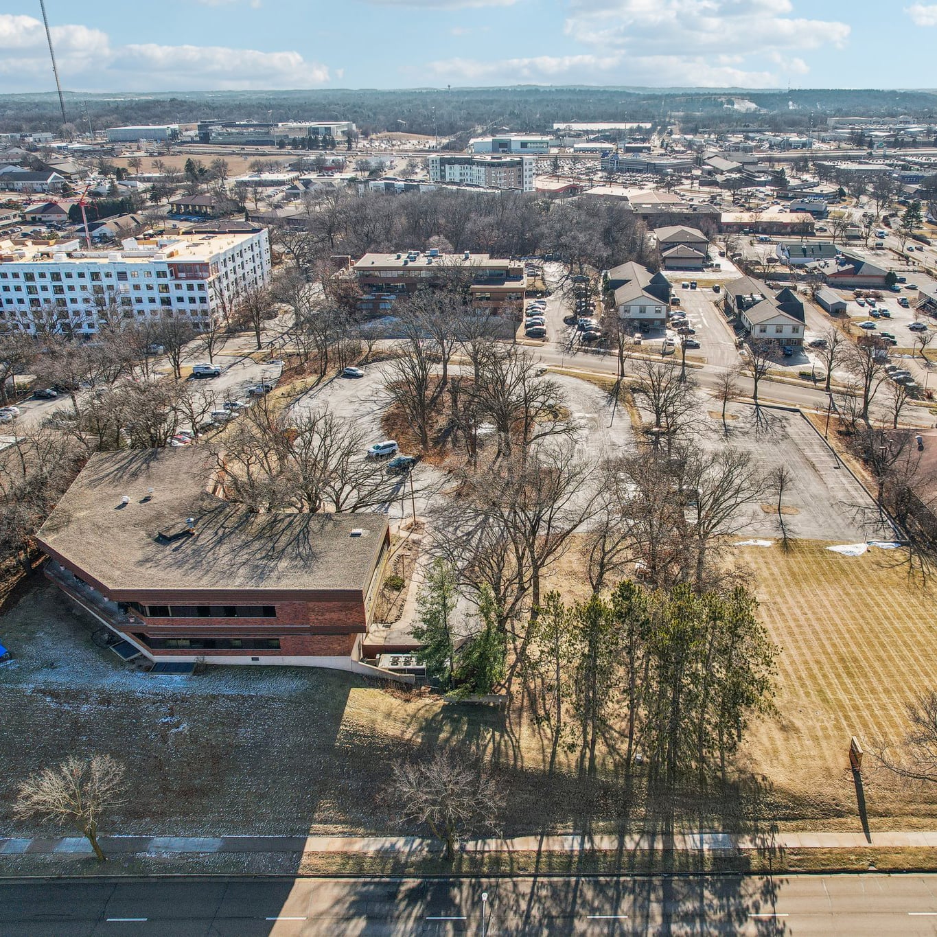 Aerial view of Grand Teton Plaza showing the commercial property, parking areas, mature trees and surrounding development.