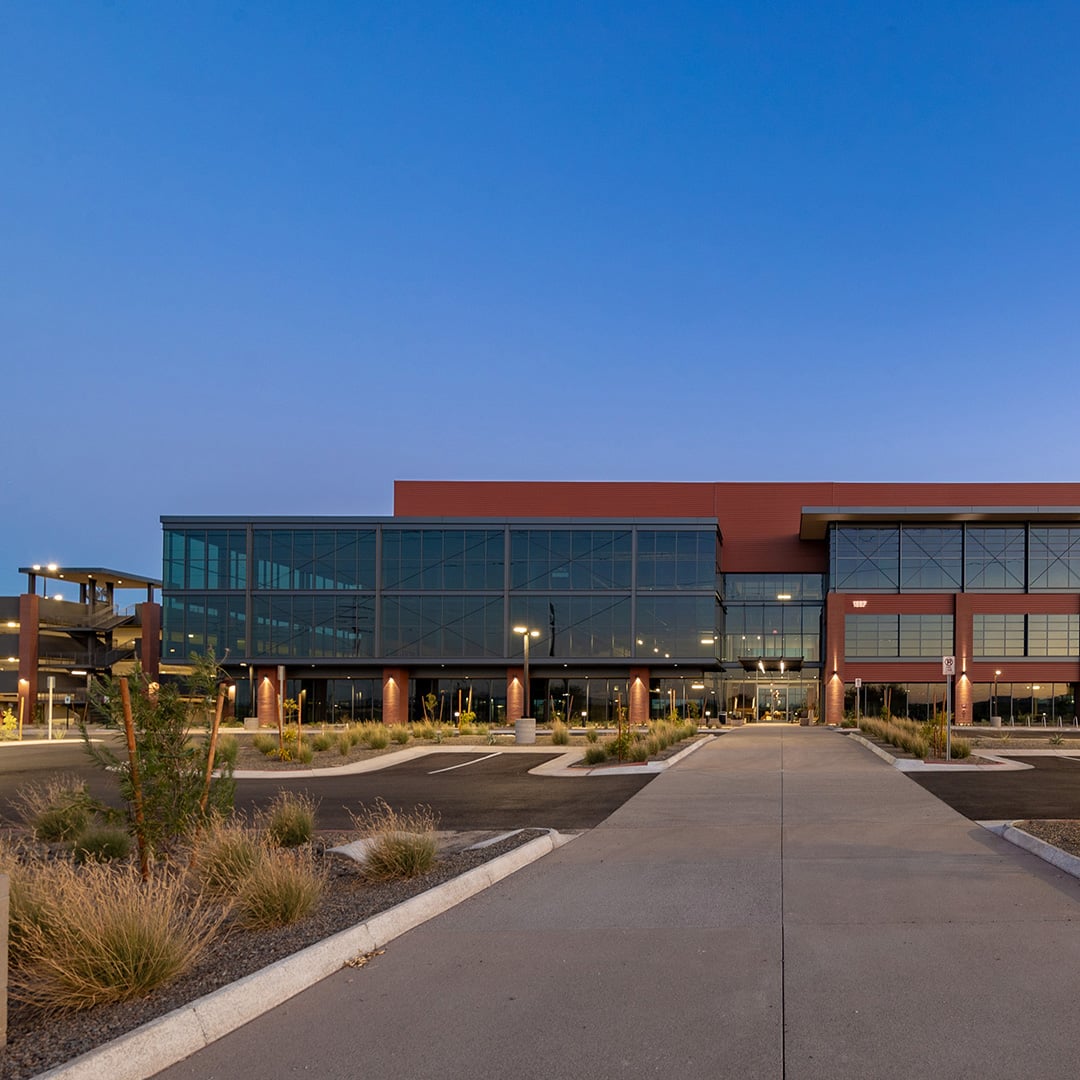 Exterior of Horizon Bay office building in Phoenix, Arizona, featuring a modern glass façade, landscaped grounds and surface parking.