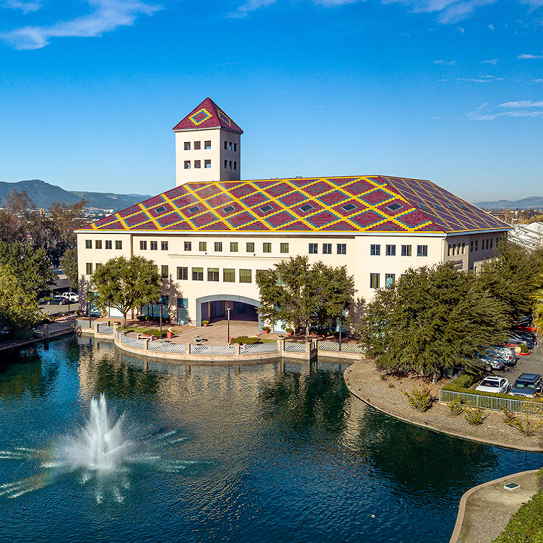 Pond with water fountain in front of office building at tower office plaza