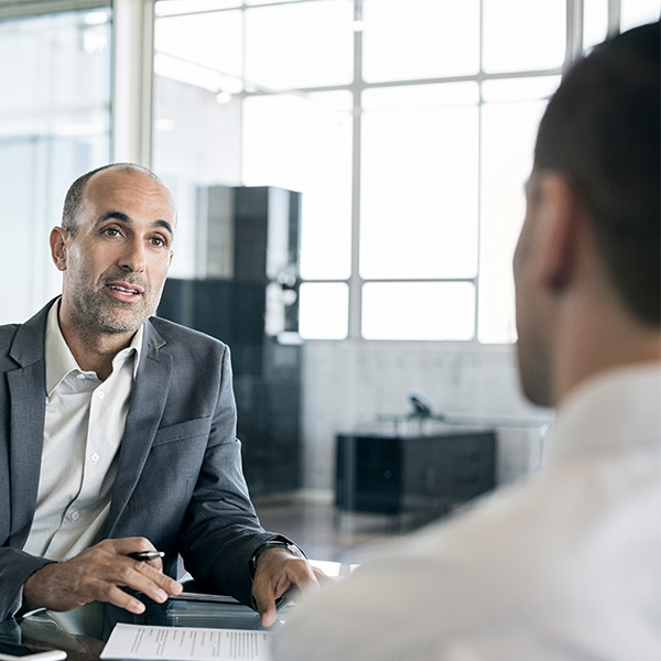 two men talking over desk