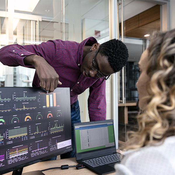 man reaching over monitor