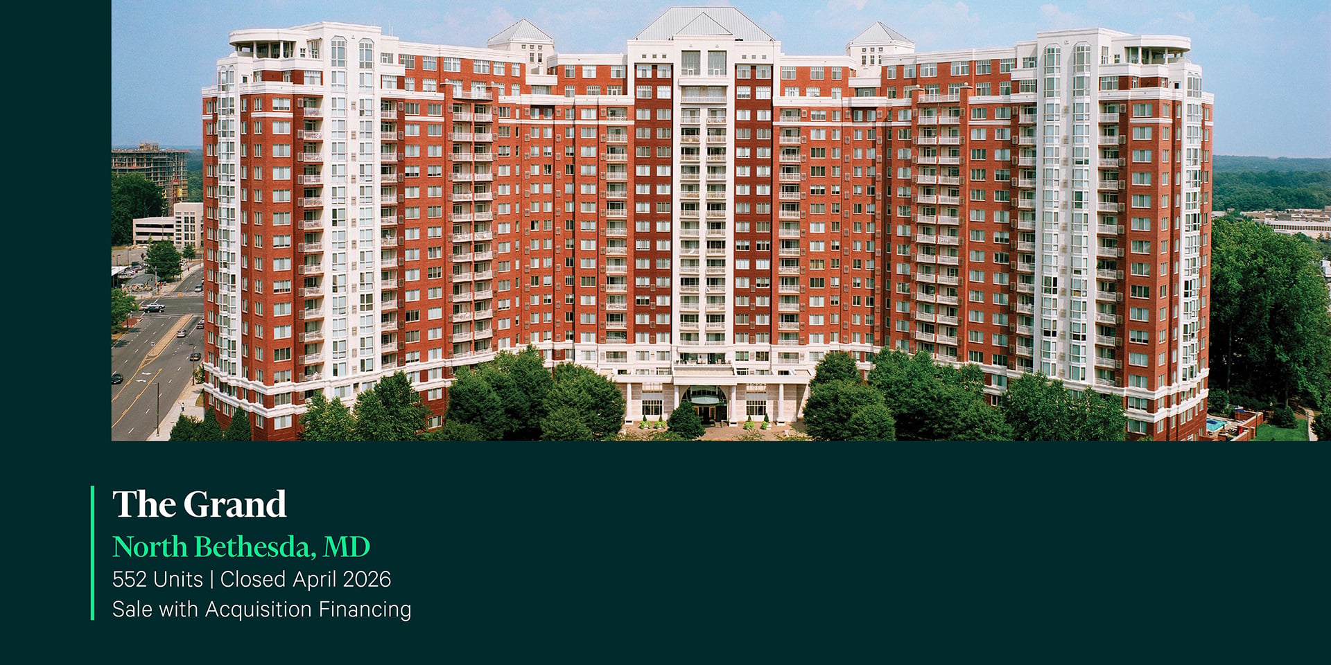 Aerial exterior of The Grand, a 552-unit luxury high-rise apartment community in North Bethesda, MD with classic red brick facade and balconies.