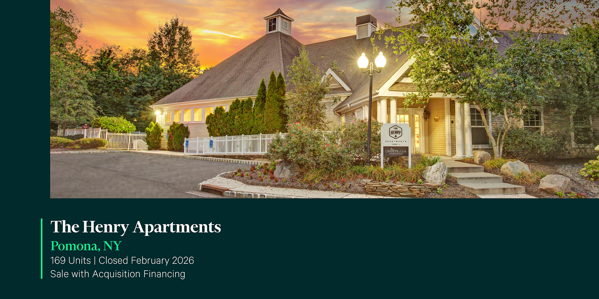 Dusk exterior of The Henry Apartments leasing clubhouse in Pomona, NY featuring a cottage-style building with columns, monument sign, and sunset sky.