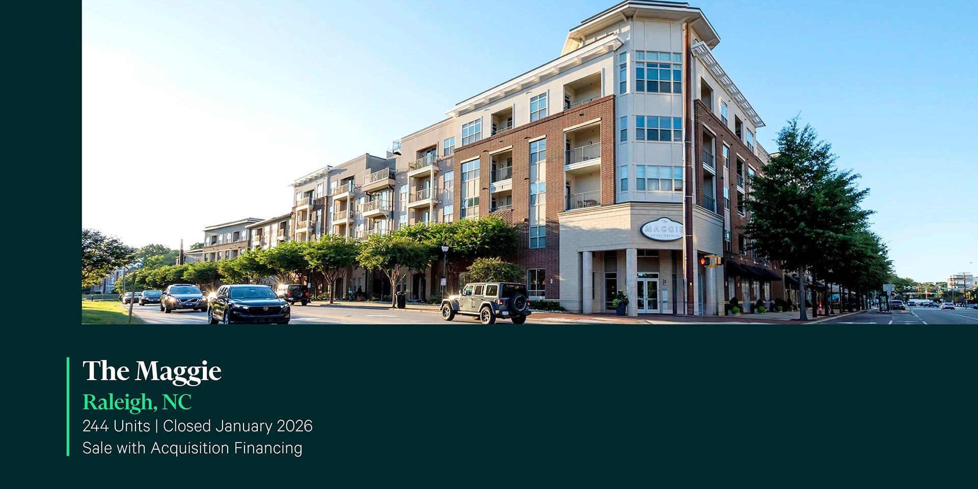 Street-level exterior of The Maggie 244-unit apartment community in Raleigh, NC featuring a five-story brick and stone mixed-use building with retail.