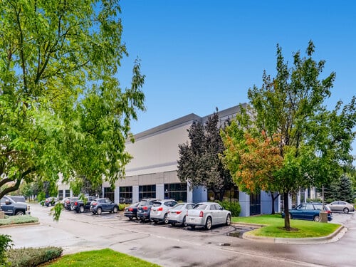 Denver-Boulder industrial portfolio flex office and warehouse building with full parking lot surrounded by mature trees on a sunny day