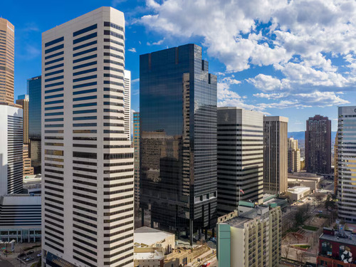 Aerial view of Granite Tower, a dark glass high-rise office building in downtown Denver's central business district surrounded by other commercial towers