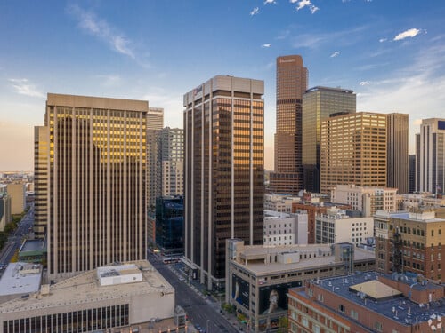 Aerial view of US Bank Tower and surrounding downtown Denver commercial office towers at golden hour with clear blue sky