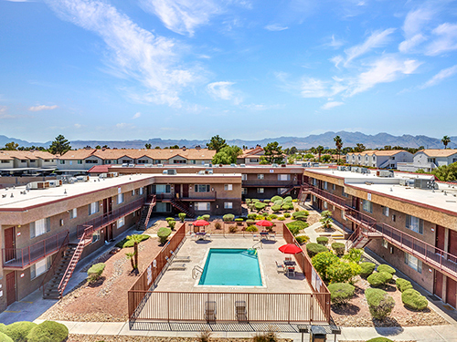 Central courtyard pool surrounded by two-story garden-style apartment buildings, showcasing shared outdoor amenities within a multifamily community.